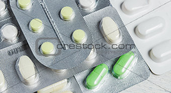Set of Various Tablets and Capsules in Blisters on White Wooden Background. Medicine Concept.