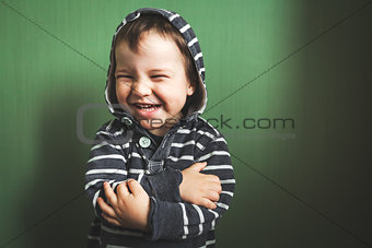 cute kid smiling boy crossing hands in pullover