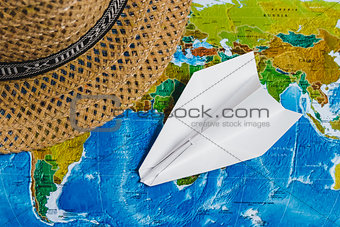 Adventure. Papercraft Plane, Hat on map. Top view. Travel Concept.