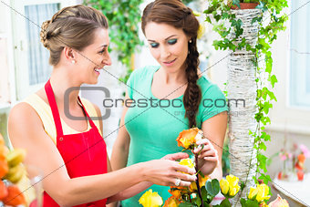 Florist woman selling rose bouquet to her customer