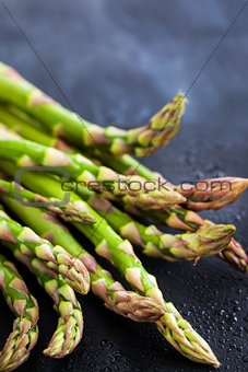 Raw fresh asparagus on dark background, close-up