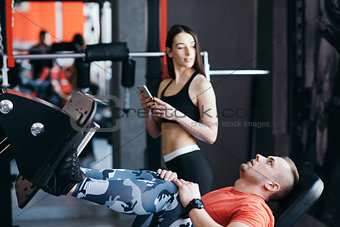 Fit man training legs on leg press machine in the gym