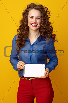 happy young woman isolated on yellow background with tablet PC