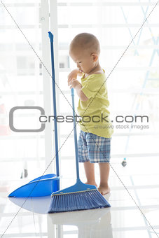 Young kid sweeping floor