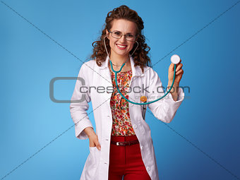 happy paediatrist woman using stethoscope on blue