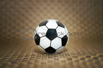 A toy soccer ball on an artificial background. Concept of the game of football.