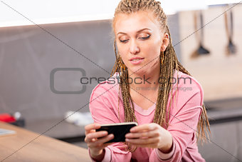 Attractive young woman reading a text message
