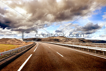 Empty highway,mountain landscape and cloudy sky.Road and car tra