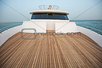 View over the bow over a large motor yacht with bridge