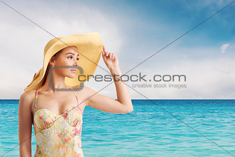 Girl with hat at the beach with a bright sea