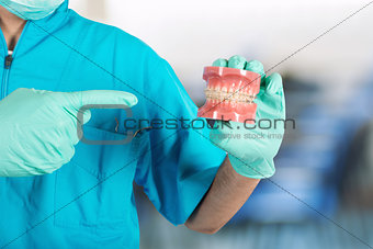 Dentist shows how to apply a brace