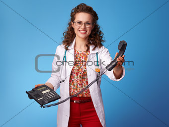 happy paediatrician doctor with phone on blue