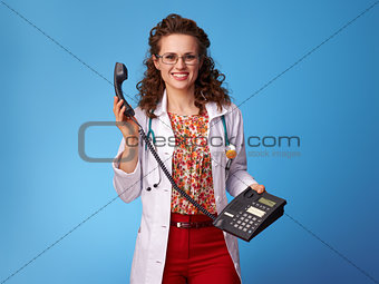 smiling pediatrist woman with phone on blue