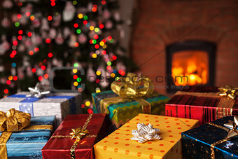 Many christmas presents in front of xmas tree and fireplace