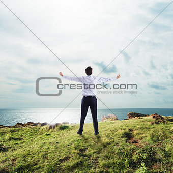 Businessman with open arms to the sky. concept of success and freedom