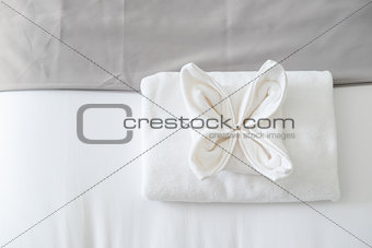 Top view of white fresh towel on bed