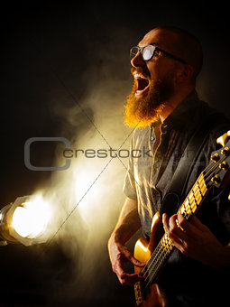Screaming bass player in front of spotlight