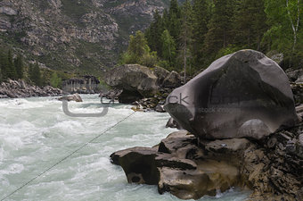 Bizarre stone on the shore of a mountain river.  Altai Mountains