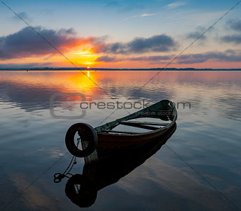 Sunrise on Lake Seliger with an old boat in the foreground
