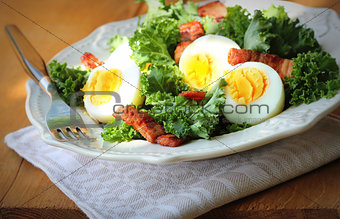Fresh healthy salad with kale, chrispy bacon and egg