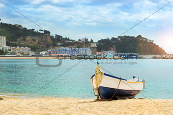 Fishing boat moored on sandy beach. Blanes, Spain