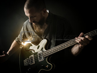 Bearded man playing bass guitar