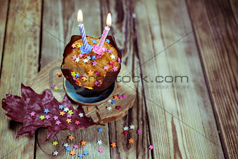 Vanilla cupcake with candle on wooden background. Birthday / Holidays greeting card